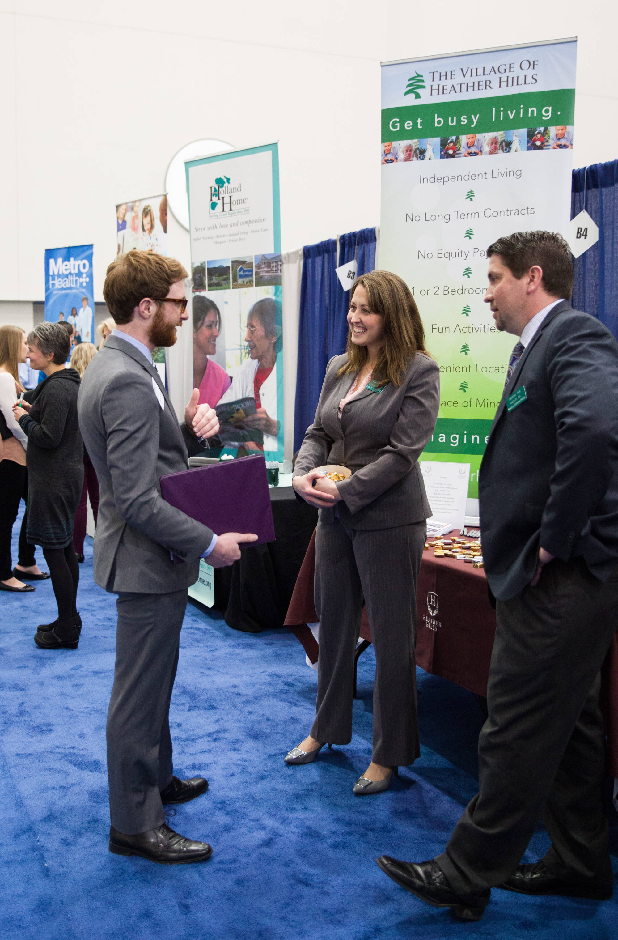 Student networking at a career fair with two business professionals